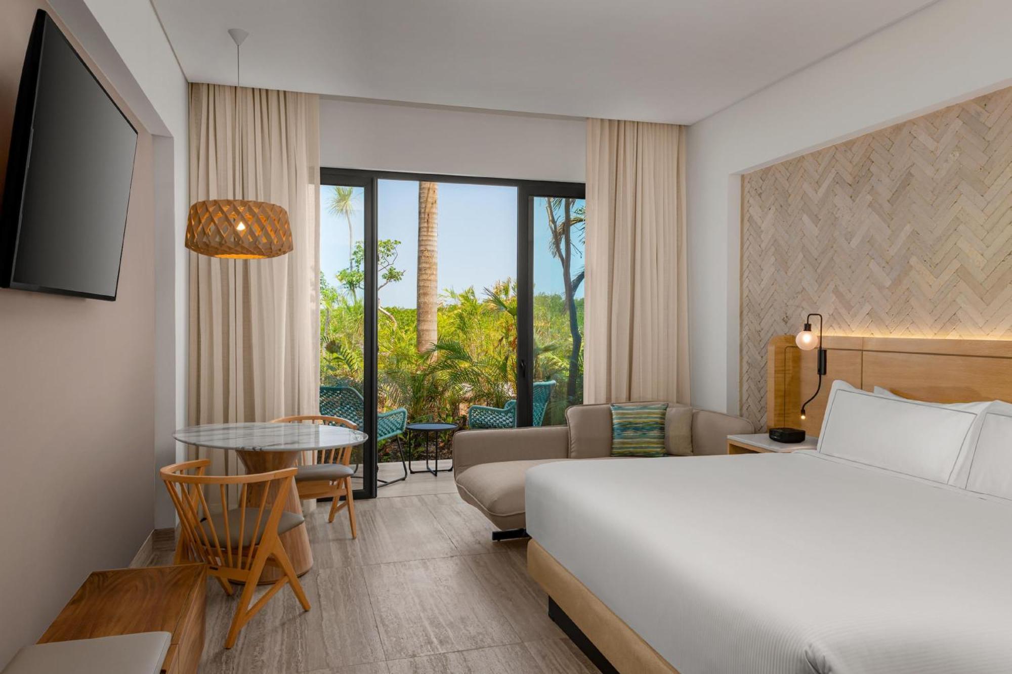 Zimmer mit Kingsize-Bett und Blick auf die Natur